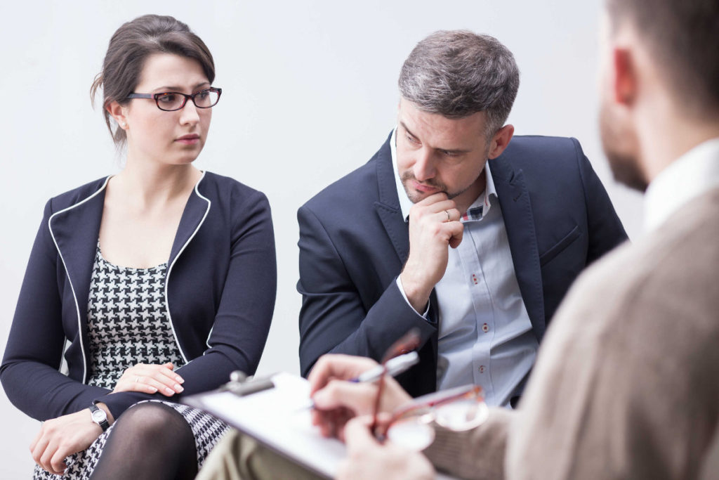 A couple sitting across from an attorney discussing divorce