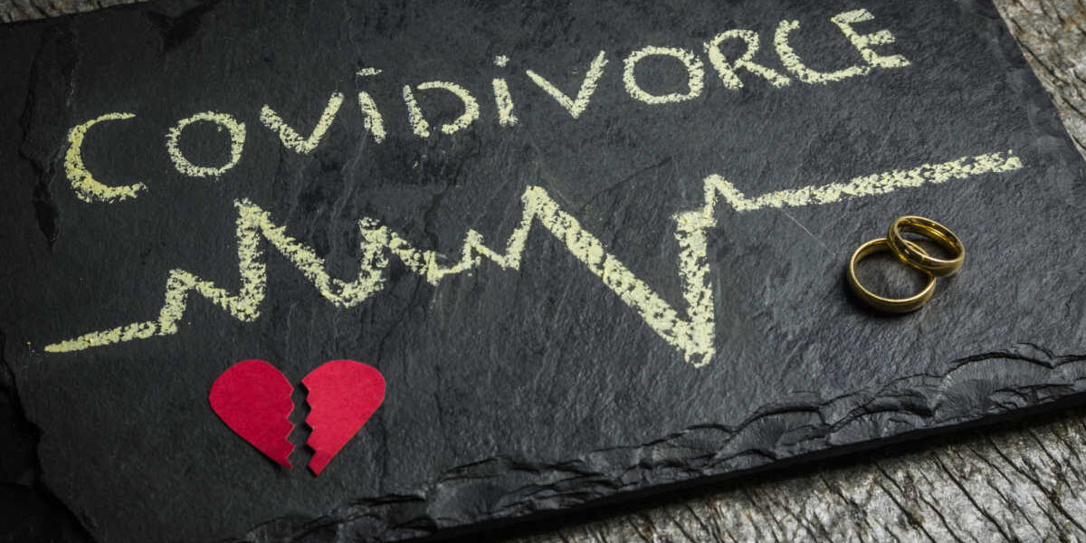 Sign stating covidivorce (covid divorce) with a read broken hear and a pair of wedding rings